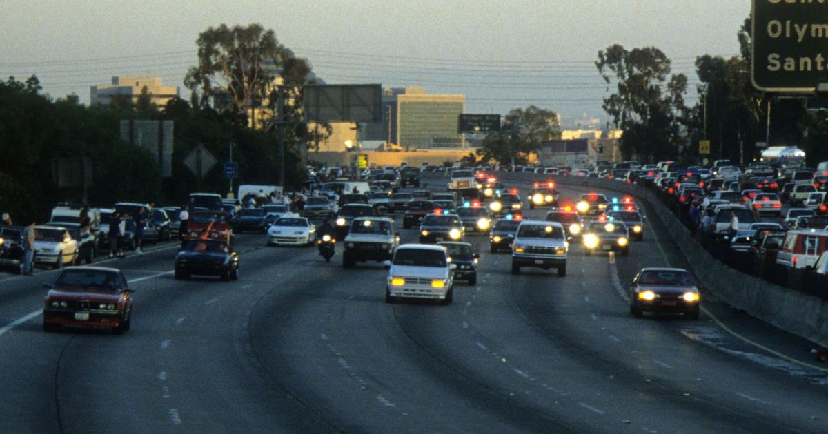 Police cars pursue the Ford Bronco driven by Al Cowlings, carrying fugitive murder suspect O.J. Simpson, on a 90-minute slow-speed car chase June 17, 1994 on the 405 freeway in Los Angeles, California.