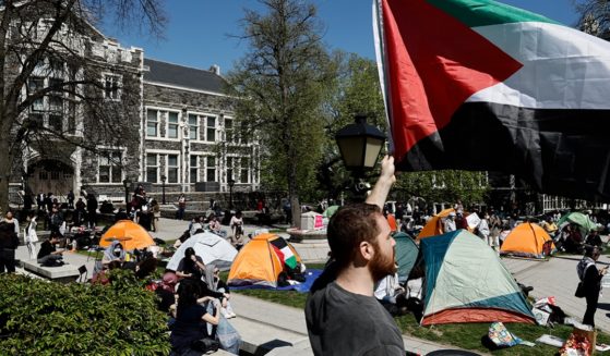 A white man holds a Palestinian flag during a protest at the City University of New York on April 25.