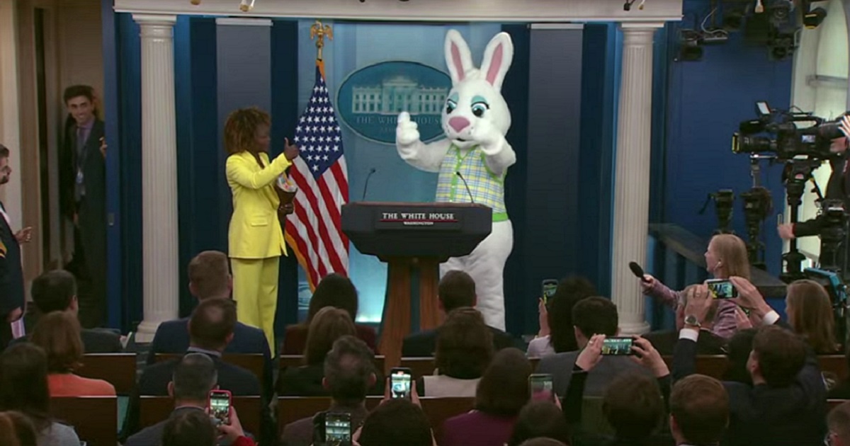 White House press secretary Karine Jean-Pierre with a character in a rabbit suit at the press room podium on Monday.