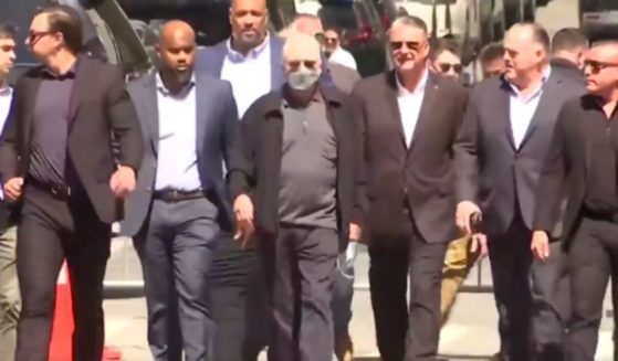 A Biden campaign representative, second from left; Robert De Niro, center; and others, including two officers present at the Capitol incursion, make their way to the media for a Biden campaign news conference outside the Manhattan courthouse on Tuesday where Trump's trial is taking place.