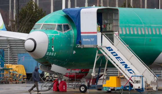 A man walks past an unpainted Boeing 737-8 MAX parked at Renton Municipal Airport adjacent to Boeing's factory in Renton, Washington, on Jan. 25.
