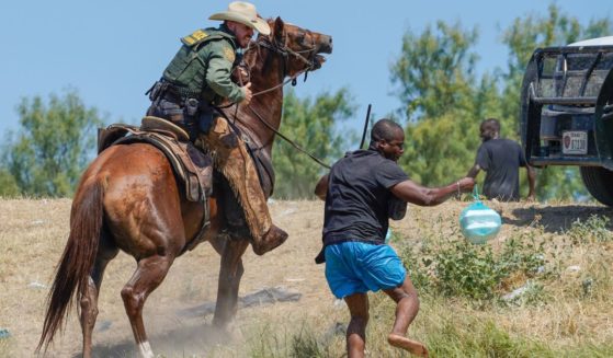 A United States Border Patrol agent on horseback uses the reins to try and stop a Haitian migrant from entering an encampment on the banks of the Rio Grande near the Acuna Del Rio International Bridge in Del Rio, Texas, on Sept. 19, 2021.