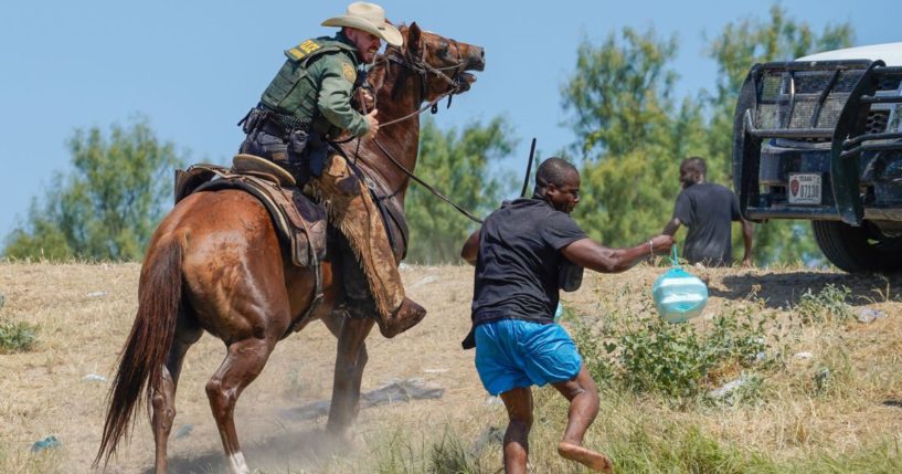 A United States Border Patrol agent on horseback uses the reins to try and stop a Haitian migrant from entering an encampment on the banks of the Rio Grande near the Acuna Del Rio International Bridge in Del Rio, Texas, on Sept. 19, 2021.