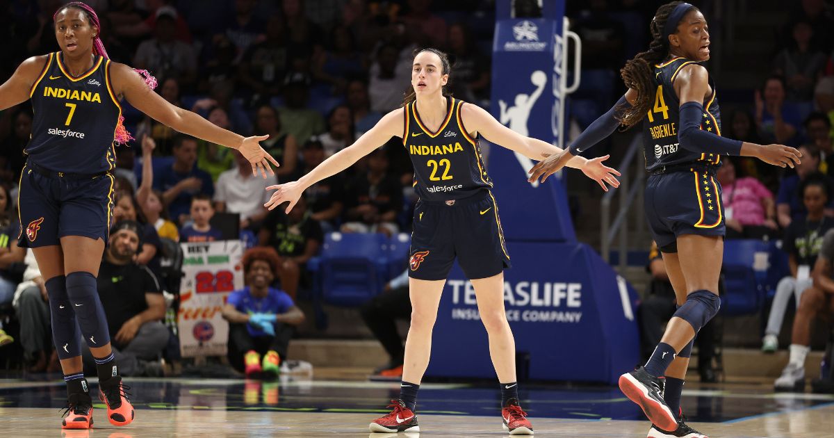 Caitlin Clark (#22) of the Indiana Fever celebrates a first-half three-pointer with Allya Boston (#7) and Tami Fagbenle (#14) while playing the Dallas Wings at College Park Center Friday in Arlington, Texas.