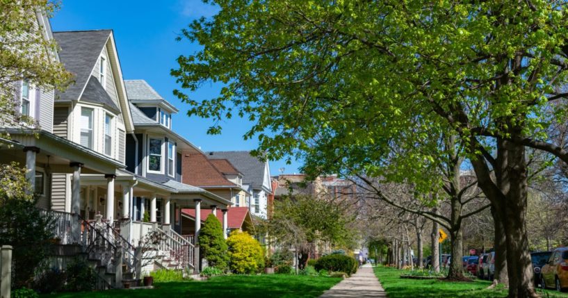 A row of old wooden homes with front lawns and a sidewalk is pictured in the North Center neighborhood of Chicago, Illinois.