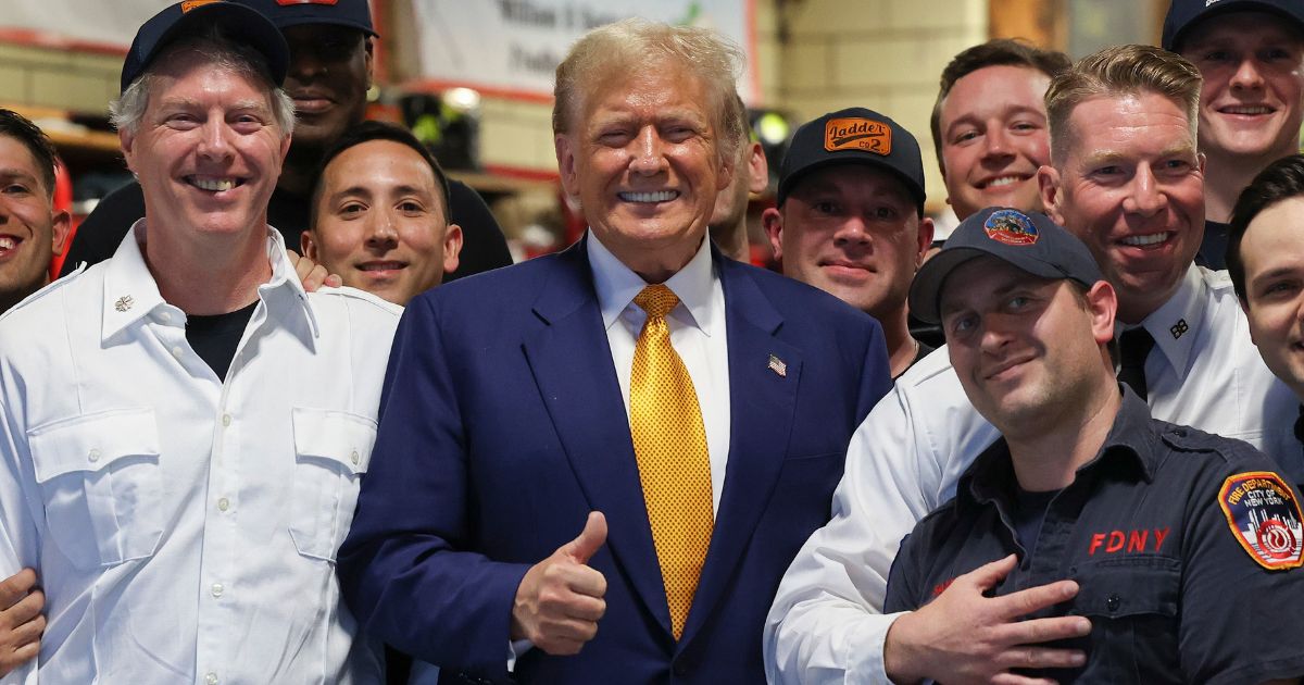 Donald Trump posing for a photo with firefighters at a midtown Manhattan firehouse