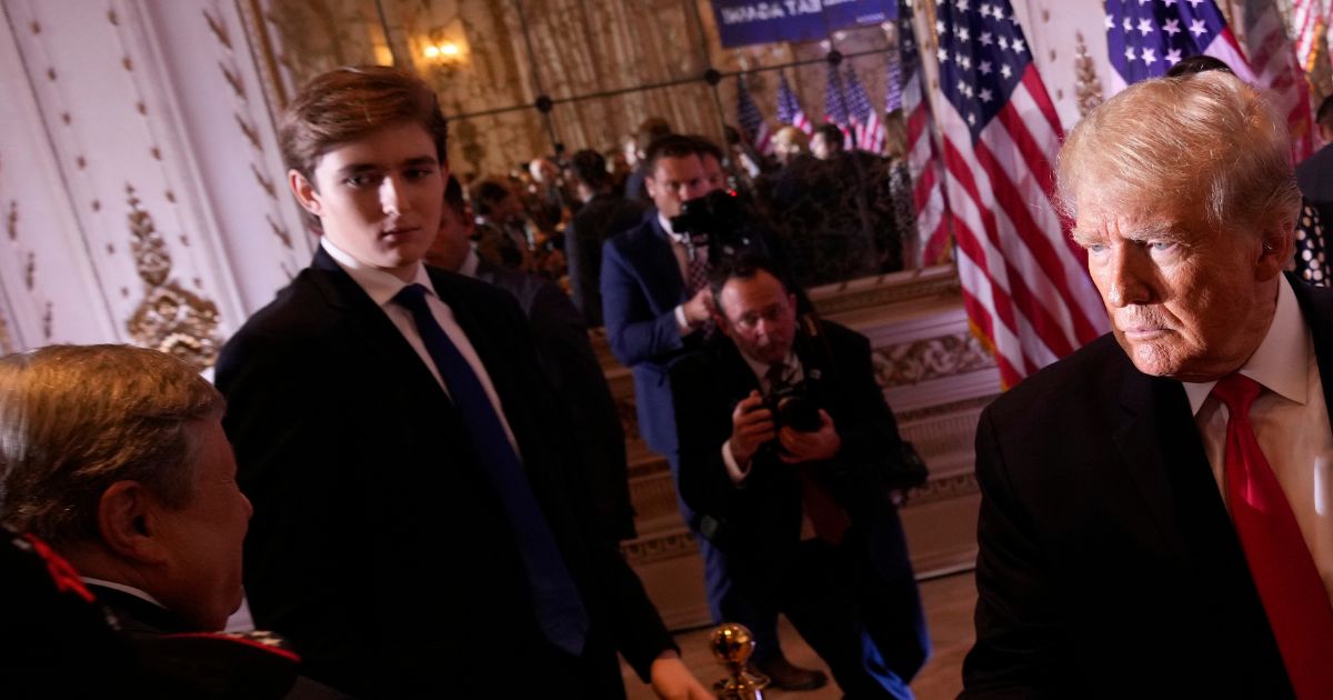 Barron Trump watches as his father greets people at Mar-a-Lago