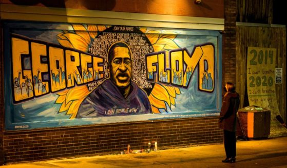 A woman looks at a mural on the wall of Cup Foods during a vigil for George Floyd in Minneapolis on May 25, 2022.