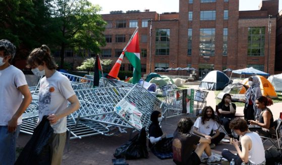 Pro-Palestinian protesters sit outside their tents in an encampment at University Yard at George Washington University in Washington, D.C., on Monday.