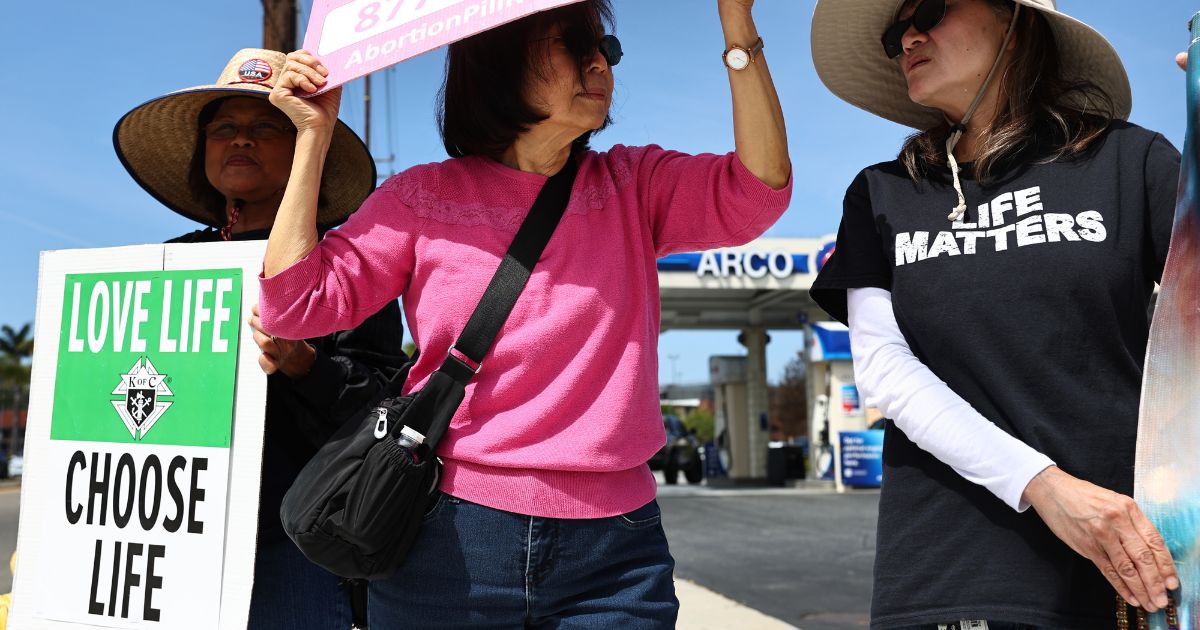 Demonstrators protest against abortion pill sales outside a CVS pharmacy March 26 in Torrance, California.