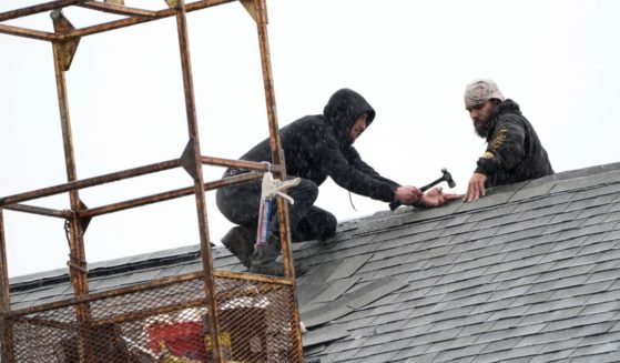 workers repairing a church roof