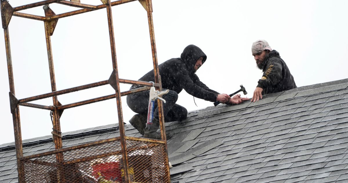 workers repairing a church roof