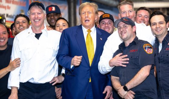 Former President Donald Trump poses for photos with members of the FDNY Engine 2, Battalion 8 firehouse on Thursday in New York City. Trump delivered pizza to a firehouse after a court appearance in his hush money trial.