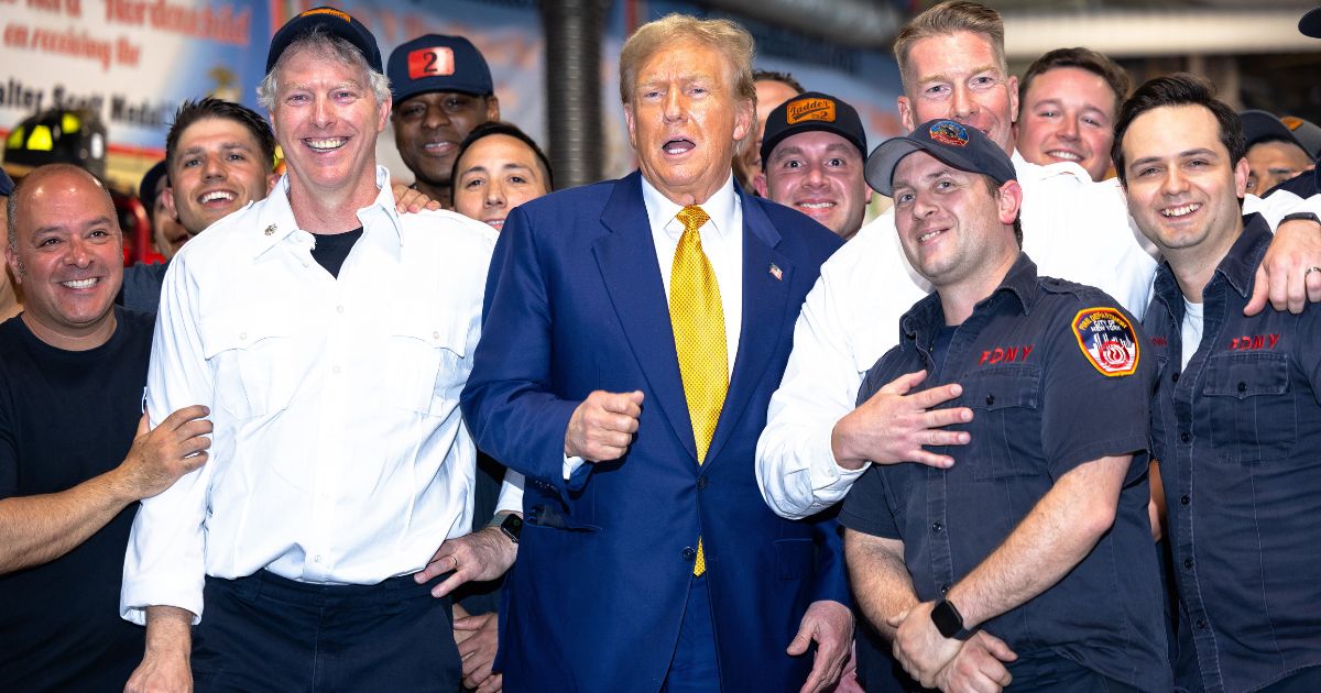 Former President Donald Trump poses for photos with members of the FDNY Engine 2, Battalion 8 firehouse on Thursday in New York City. Trump delivered pizza to a firehouse after a court appearance in his hush money trial.