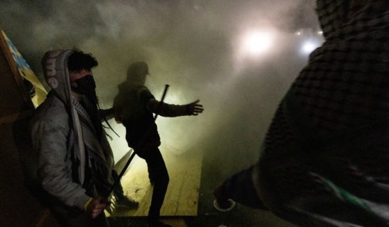 Pro-Palestinian demonstrators attempt to rebuild a barricade around their encampment while surrounded in tear gas on the campus of the University of California Los Angeles on Wednesday.