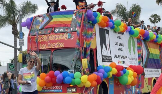 Members of the Hollywood United Methodist Church wave from a top a sightseeing bus decorated with rainbow-colored balloons and flags during the LA "Pride" Parade in Hollywood on June 11, 2023.
