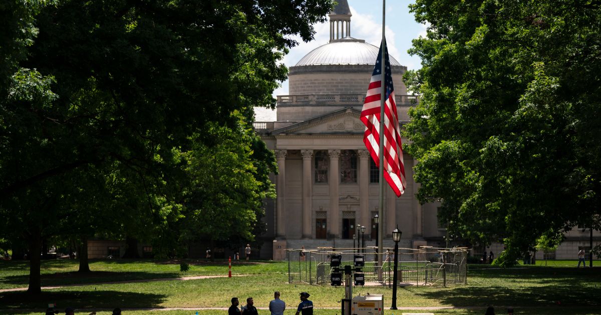 A barricade protects the American flag at Polk Place at the University of North Carolina on Wednesday in Chapel Hill, North Carolina. On Tuesday, protesters removed an American flag and raised a Palestinian flag following a dispersed encampment at Polk Place on the campus of the University of North Carolina.