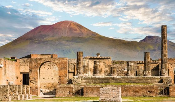 Ancient walls in Pompeii, with Mount Vesuvius in the background.