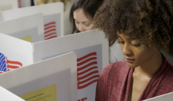 Two young women cast their vote at a polling station.