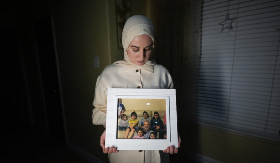 Maryam Kamalmaz hold a photo of her father with some of his 14 grandchildren in Grand Prairie, Texas, in a file photo from Jan. 17. U.S. officials have developed intelligence suggesting that Majd Kamalmaz, an American citizen who disappeared seven years ago while traveling in Syria has died,