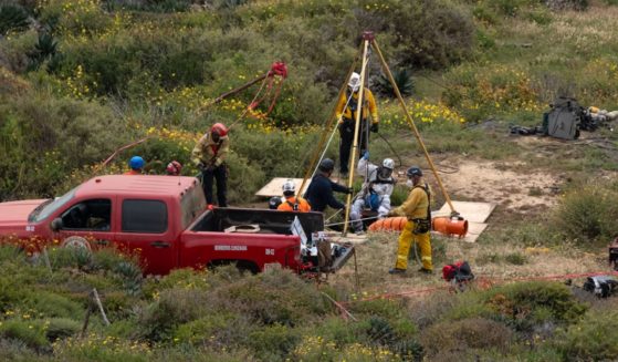 Investigators on the scene at a well on Friday in the Mexican state of Baja California where the bodies of a missing American and two Australian brothers were found.
