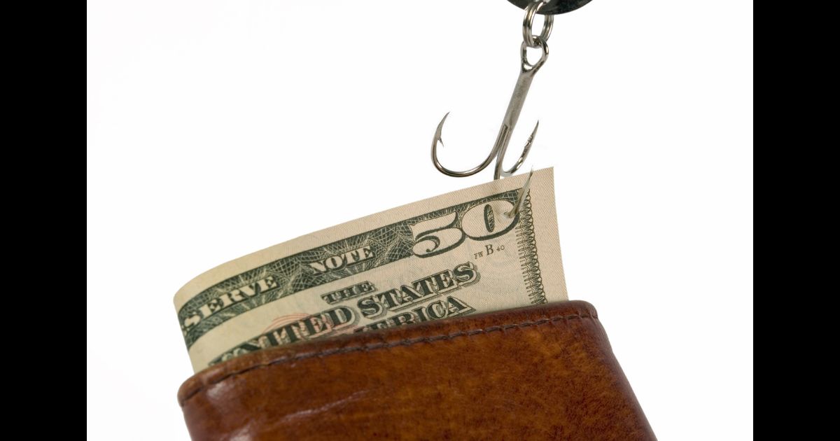 This Getty stock image shows a $50 bill stuck on a fishing hook, being pulled out of a wallet.
