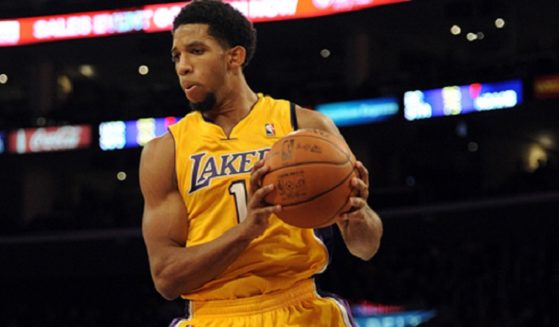 Former NBA player Darious Morris, pictured in a 2011 file photo, holds the ball after snagging a rebound against the Los Angeles Clippers during his time with the Los Angeles Lakers.
