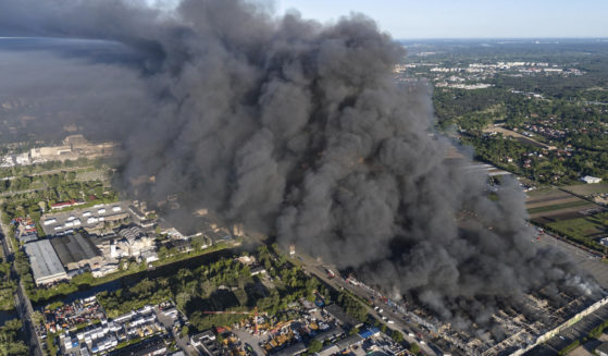 A fire burns from a vast shopping complex in Warsaw, Poland, on Sunday, May 12, 2024. The fire broke out Sunday morning in a vast shopping complex in the Polish capital that housed some 1,400 shops and service outlets and where many of the vendors were from Vietnam.