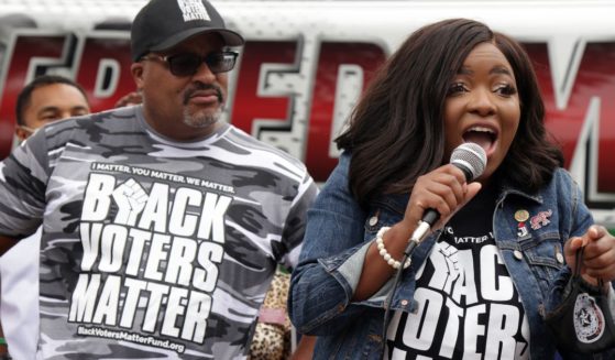 Texas State Rep. Jasmine Crockett (D-100) (R) speaks as Co-founder and Executive Director of Black Voters Matter Cliff Albright (L) looks on during a demonstration on voting rights outside National Museum of African American History and Culture August 4, 2021 in Washington, DC.