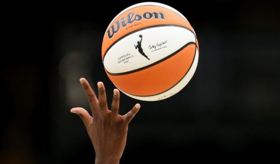 The WNBA logo is seen on the basketball during the opening tipoff of a 2023 game.