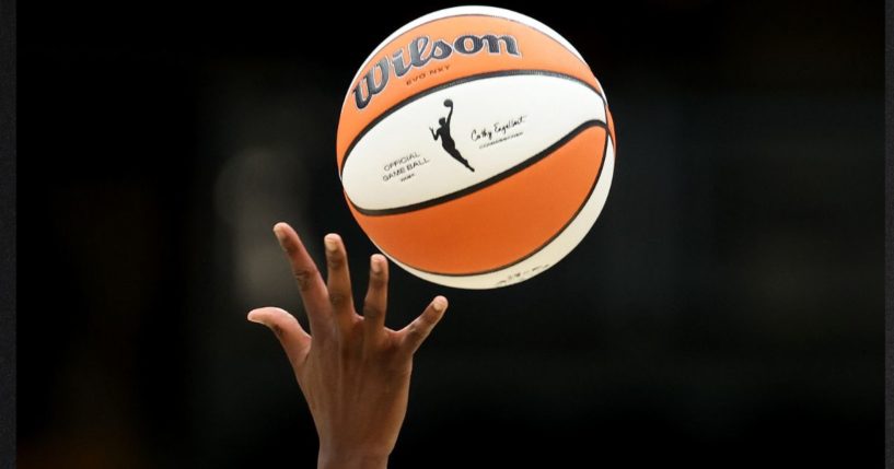 The WNBA logo is seen on the basketball during the opening tipoff of a 2023 game.