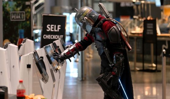 A cosplayer dressed as Boba Fett uses a self checkout machine during New York Comic Con 2022 on October 7, 2022 in New York City.