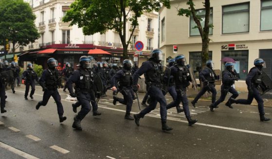 Anti-riot police officers run as they charge during clashes with protesters during a demonstration called by Kanak organisations, "Urgence Palestine" group and anti-fascist movements in Paris on June 1, 2024.