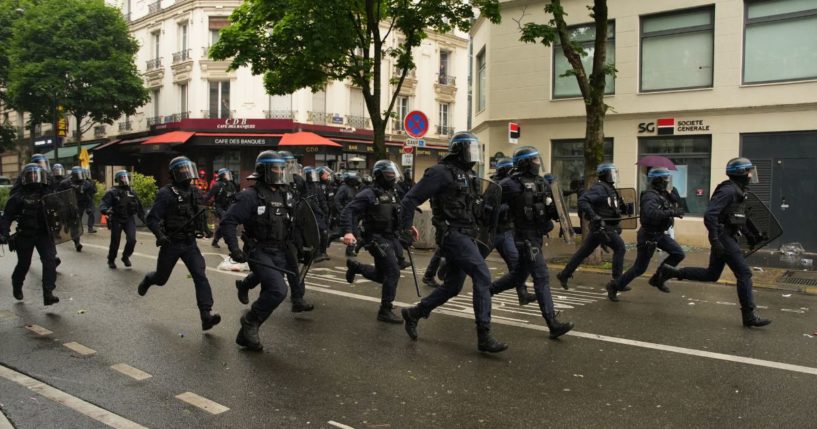 Anti-riot police officers run as they charge during clashes with protesters during a demonstration called by Kanak organisations, "Urgence Palestine" group and anti-fascist movements in Paris on June 1, 2024.