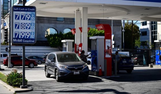 A customer uses a credit card to pump gas as a sign shows gasoline fuel prices above average at over seven and approaching eight dollars a gallon at a Mobil gas station in Los Angeles, California, on October 5, 2023.