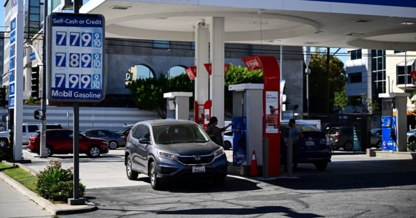 A customer uses a credit card to pump gas as a sign shows gasoline fuel prices above average at over seven and approaching eight dollars a gallon at a Mobil gas station in Los Angeles, California, on October 5, 2023.