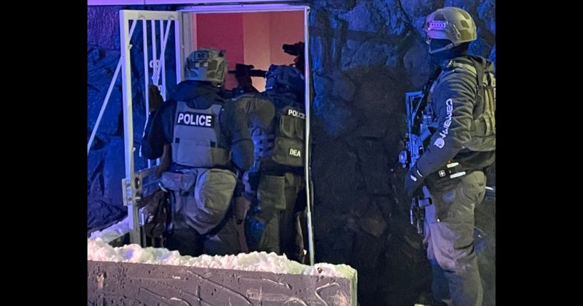 DEA agents enter a building during a raid in Denver, Colorado, on Sunday.