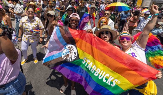 Marchers with Starbucks pass through the landmark intersection of Hollywood and Highland during the annual Pride Parade on June 12, 2022 in the Hollywood section of Los Angeles, California.