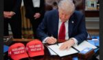 President Donald Trump signs an executive order Wednesday in the Oval Office at the White House in Washington, D.C.