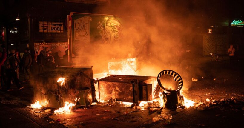 A fire burns in the street after rioters clashed with police officers near the Seattle Police Departments East Precinct in Seattle, Washington, on June 8, 2020.