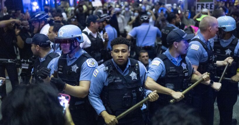 Police officers face off with immigrant-rights protesters June 10 in Chicago, Illinois. Like many Democrat-led cities, the Chicago Police Department is still suffering the aftereffects of the "defund the police" movement five years ago. The department is currently short about 1,300 officers.