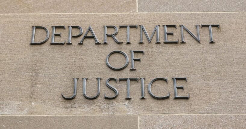 A sign is displayed outside of the Robert F. Kennedy U.S. Department of Justice building in Washington, D.C., in June.