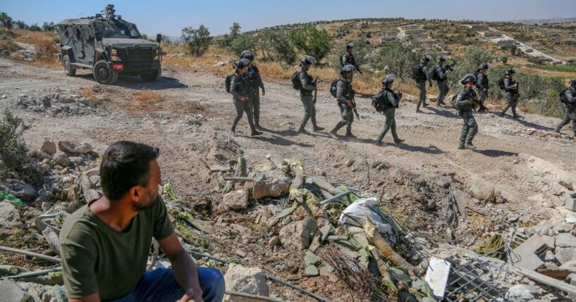 A Palestinian man sits near the rubble of his home as Israeli forces carry out demolitions in Idhna, west of Hebron, West Bank, on April 28, 2025.
