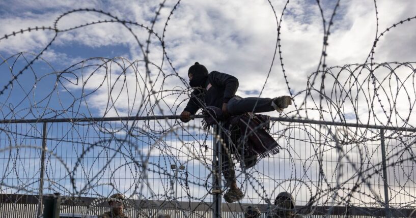 A migrant from Venezuela climbs over a border fence in an attempt to enter and seek asylum in El Paso, Texas, from Ciudad Juarez, Chihuahua, Mexico, on April 2, 2024.