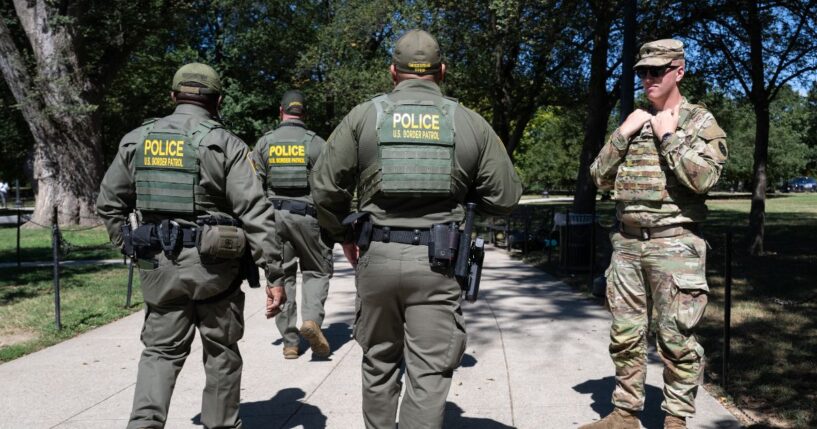 U.S. Border Patrol agents walk down a sidewalk on th National Mall near the World War II Memorial in Washington, DC, on Aug. 25, 2025.