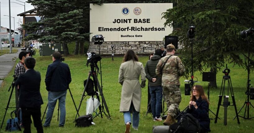 Journalists work near an entrance to Joint Base Elmendorf-Richardson in Anchorage, Alaska, Thursday, ahead of Friday's scheduled meeting between President Donald Trump and Russian President Vladimir Putin.