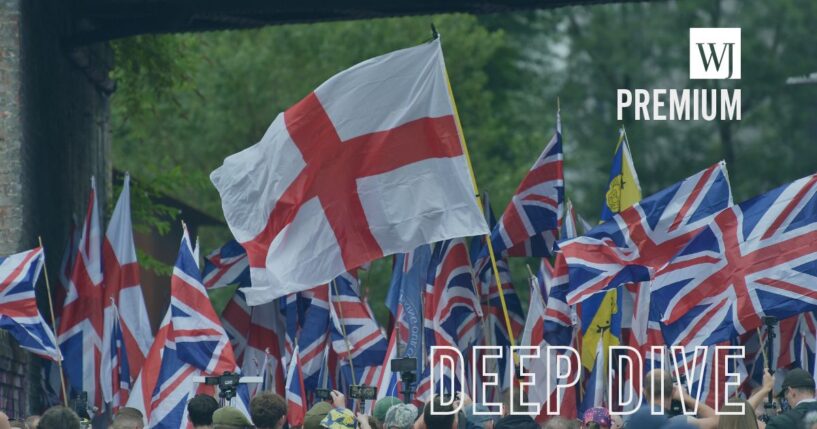 Britain First party supporters carry Union Flags and St George Cross flags during a "'March for Remigration" protest in Manchester, England, on Aug. 2.