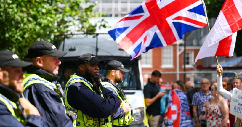 Police are seen with anti-illegal immigration protesters as they demonstrate outside the Roundhouse Hotel on Aug. 9, 2025, in Bournemouth, England.