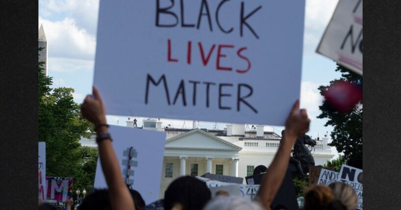 Demonstrators protesting the death of George Floyd hold up placards up near the White House on May 31, 2020 in Washington, D.C.