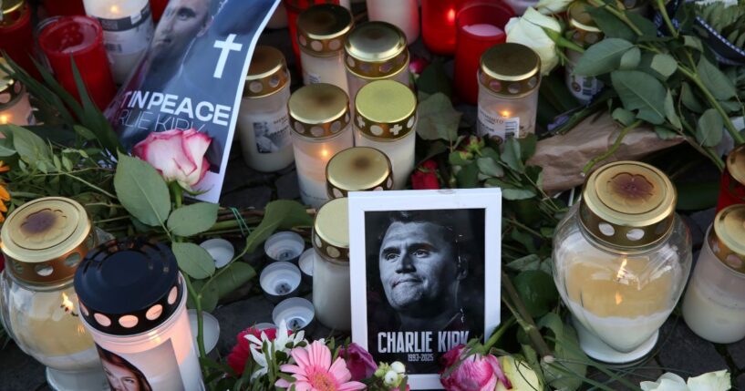 Flowers and candles are seen at a makeshift memorial for murdered American conservative activist Charlie Kirk outside the U.S. embassy as its flag hangs at half-staff on Sept. 14, 2025, in Berlin, Germany.